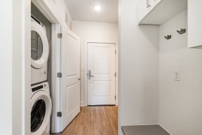 a washer and dryer in a laundry room with a white door  at City View Apartments, Lansing, MI