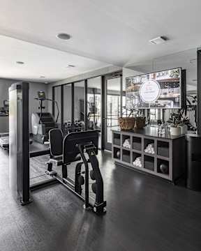 A modern gym with a variety of equipment including a treadmill, a stationary bike, and a rowing machine.