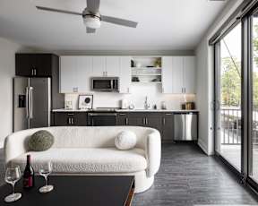 A modern kitchen with a white couch and a ceiling fan.