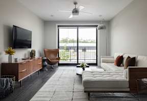 A modern living room with a large window and a flat screen TV.
