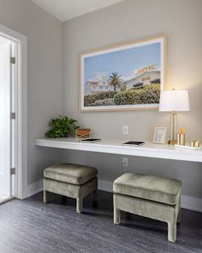 A hotel sign is on a picture hanging on a wall above a desk.