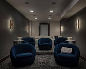 A room with blue chairs and a grey carpet.