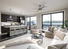 A modern living room with a bar area and a view of the water.