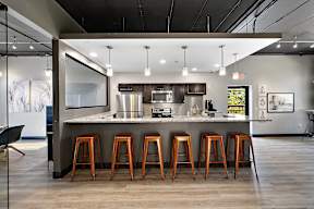 A modern kitchen with a bar area and stools.