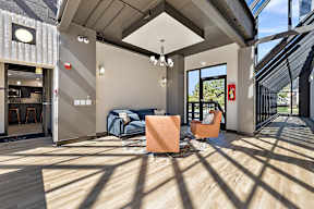 A modern living room with a blue sofa and orange chairs.