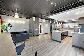 A modern office space with a kitchen area and seating.