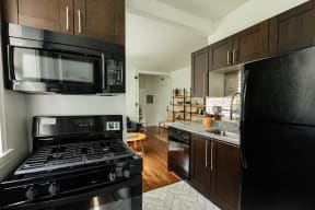 a kitchen with black appliances and dark wood cabinets