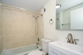 A bathroom with a toilet, sink, and shower.