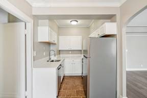 A kitchen with white appliances and cabinets.