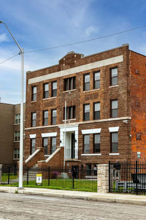 a red brick building with a black fence in front of it