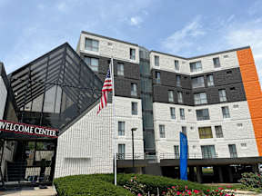 A modern building with a black and white facade and a large American flag in front.