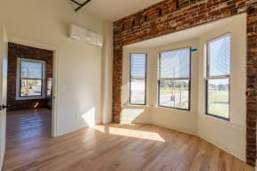 an empty room with a brick wall and hardwood floors