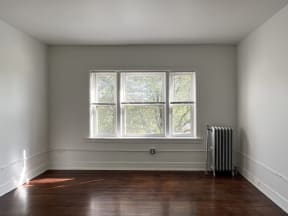 an empty room with a radiator and a large window