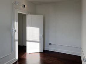 a bedroom with a white door and white walls