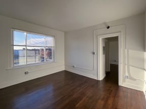 a bedroom with hardwood floors and a large window