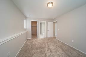a spacious living room with carpet and white walls