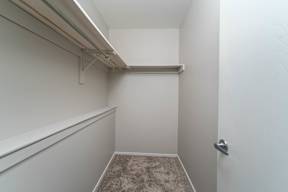 a walk in closet with white walls and a white door