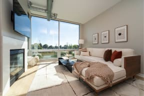 a living room with a couch and a fireplace and a large window
