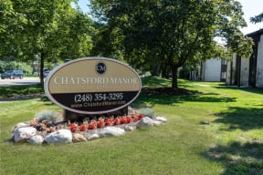 a sign in the grass in front of a park