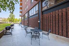 our apartments have a patio with tables and chairs and a grill