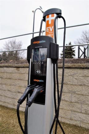 a gas pump sitting in front of a brick wall