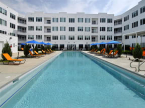 a large swimming pool with a white building in the background