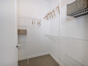 a walk in closet with white walls and a white door