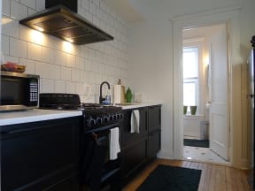 a kitchen with black cabinets and white tiles