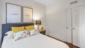 a bedroom with a bed and two paintings on the wall