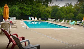 a swimming pool with chairs and chairs around it