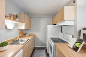 A kitchen with white appliances and wooden cabinets.