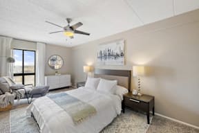 A bedroom with a large bed and a ceiling fan.