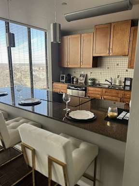 A kitchen with brown cabinets and a black counter top.