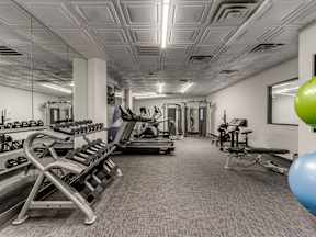 A gym with a variety of equipment including weights and treadmills.