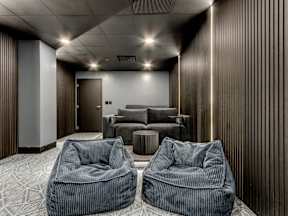 Two grey bean bag chairs are placed in a room with a grey carpet.