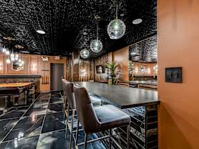 A bar with a black ceiling and a wooden wall.