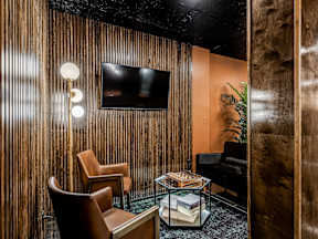 A room with a wooden wall and a television mounted on it.