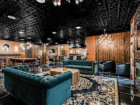 A room with a dark ceiling and a green couch.