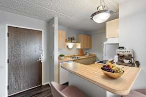 A kitchen with a wooden table and a bowl of fruit on it.