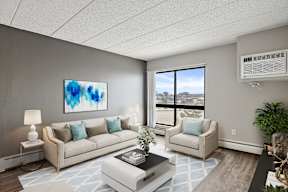A living room with a large painting on the wall and a view of the city outside the window.