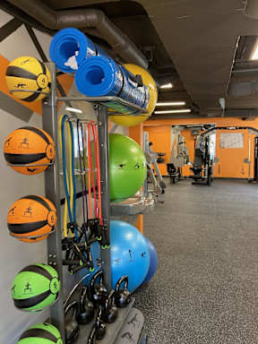 A gym with a variety of equipment including kettlebells and resistance bands.