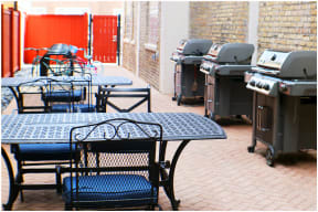 a patio with tables and bbq grills