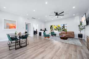 A spacious living room with a dining table and chairs.
