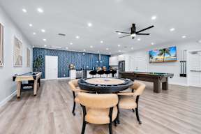 A room with a pool table and a ceiling fan.