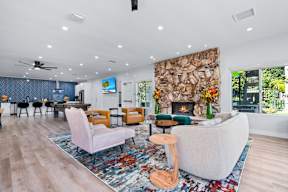 A living room with a stone fireplace and a large couch.