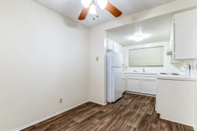 An empty kitchen with white appliances and a white refrigerator.