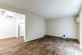 an empty living room with white walls and wood flooring