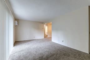 an empty living room with white walls and carpet