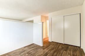 an empty living room with white walls and wood flooring