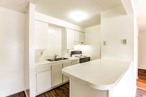 A kitchen with white cabinets and a counter top and a sink.
